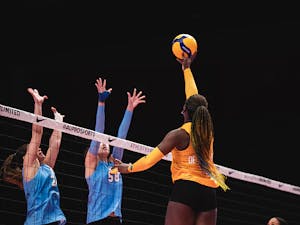 Bethania De La Cruz tips the volleyball over the net.