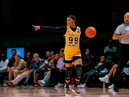 Odyssey Sims points to teammate as she dribbles down the court.