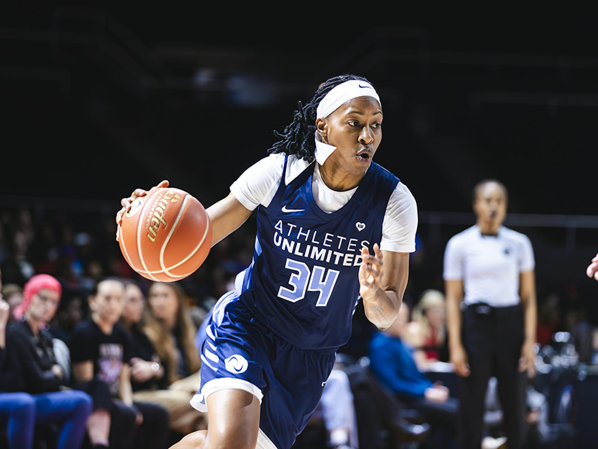 Shey Peddy, in her blue Athletes Unlimited Pro Basketball jersey, dribbles the basketball in front of the crowd in Nashville.